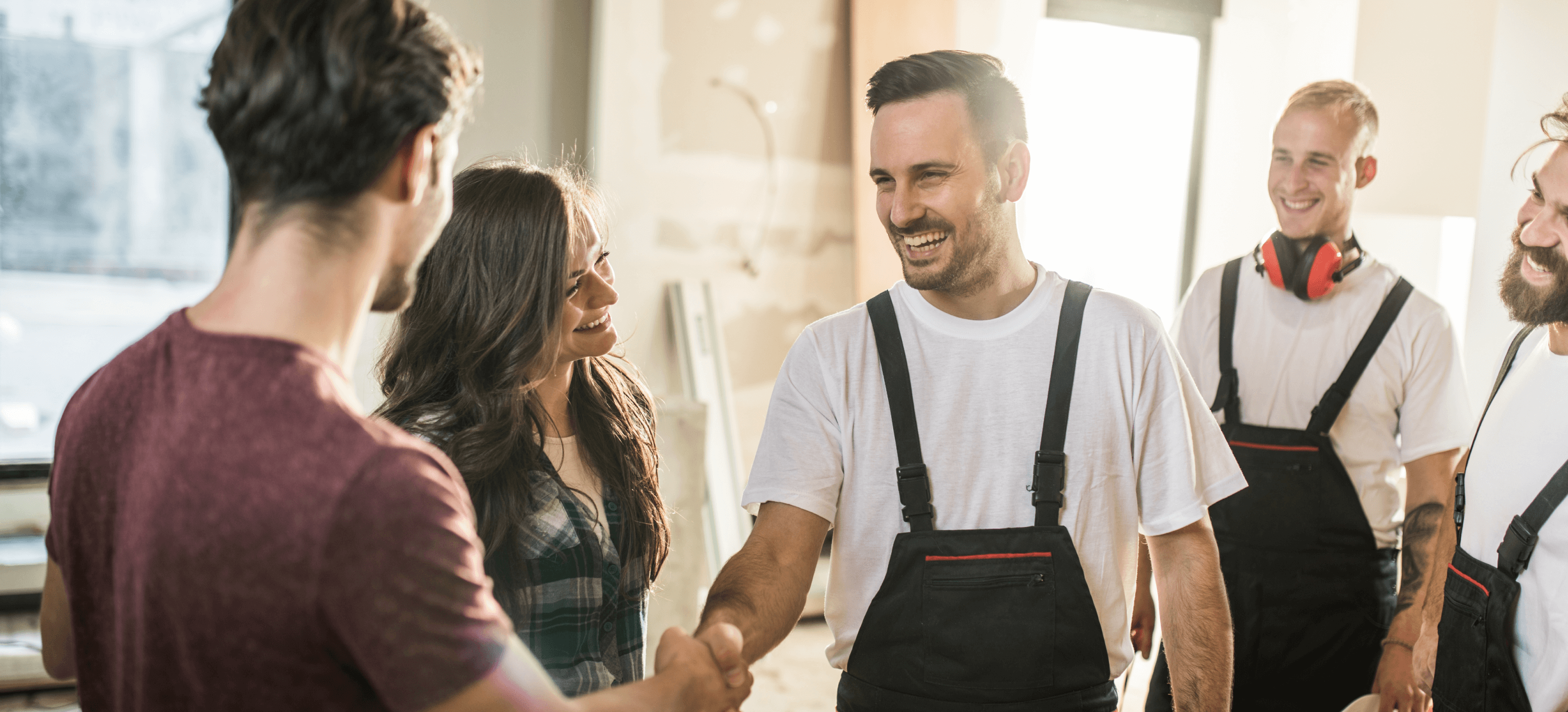 Smiling coworkers handshake determinedly in a casual workplace.