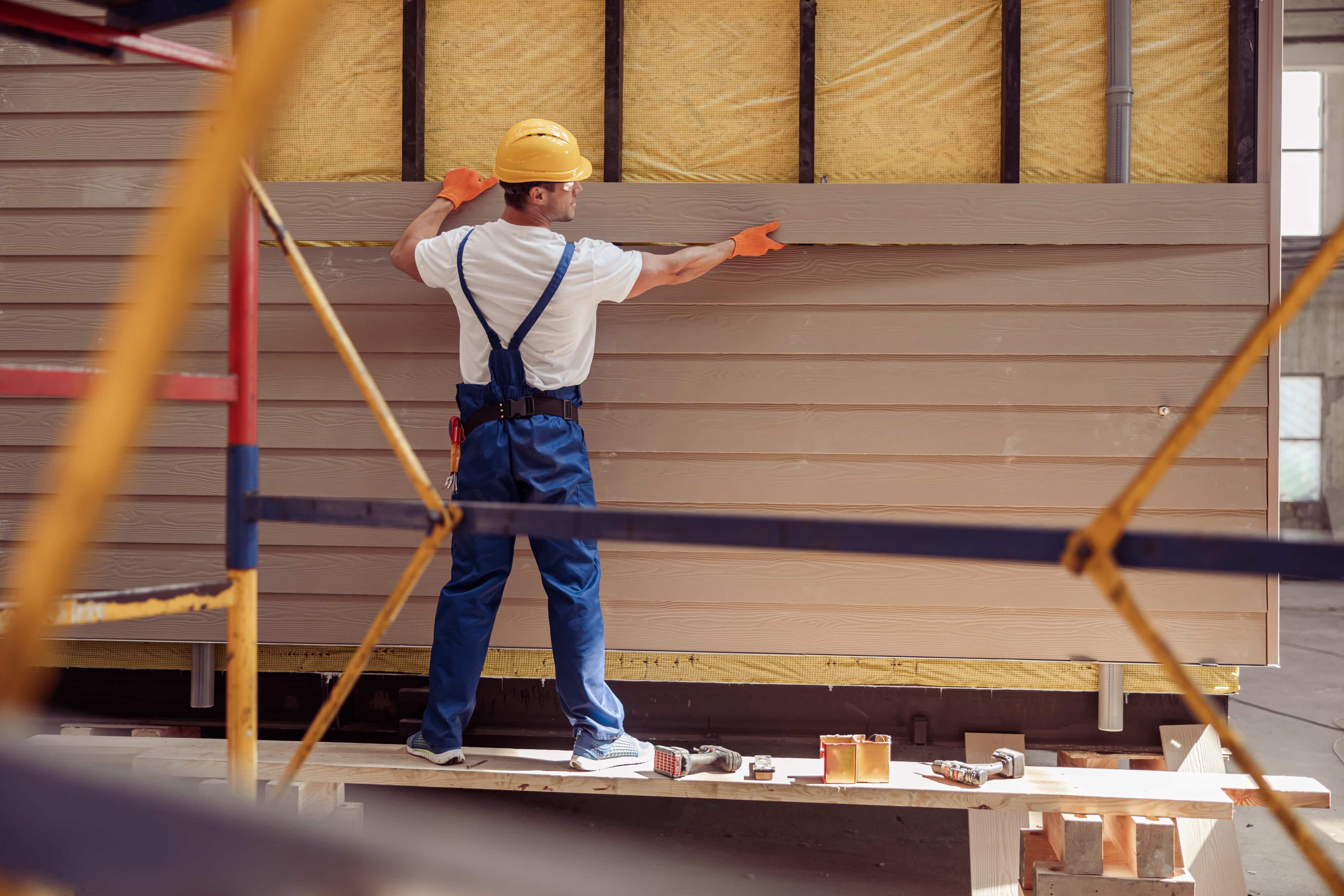 Worker gauging the cost of a siding panel.